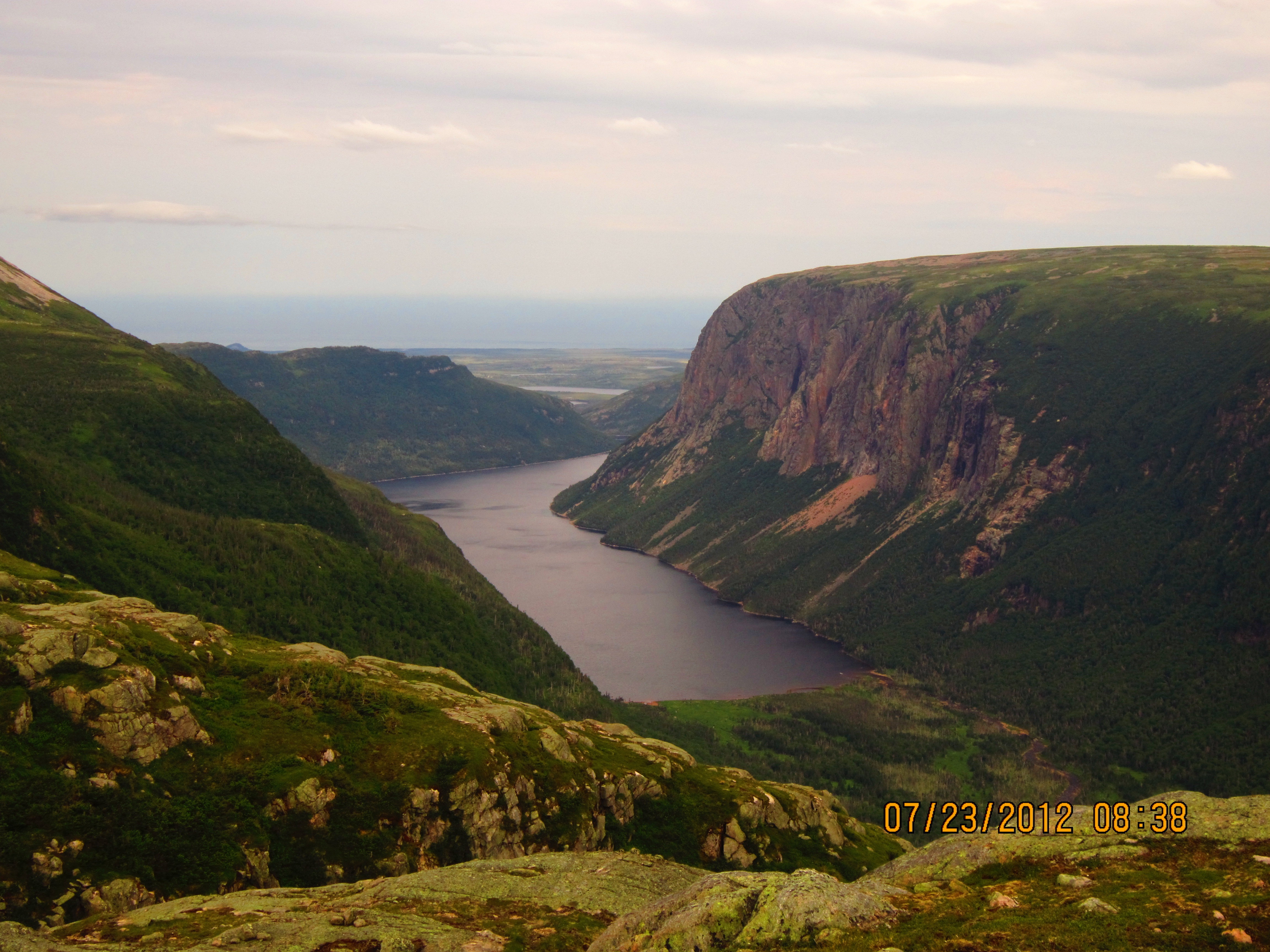 Two hikers navigating through a misty, barren landscape in Newfoundland.