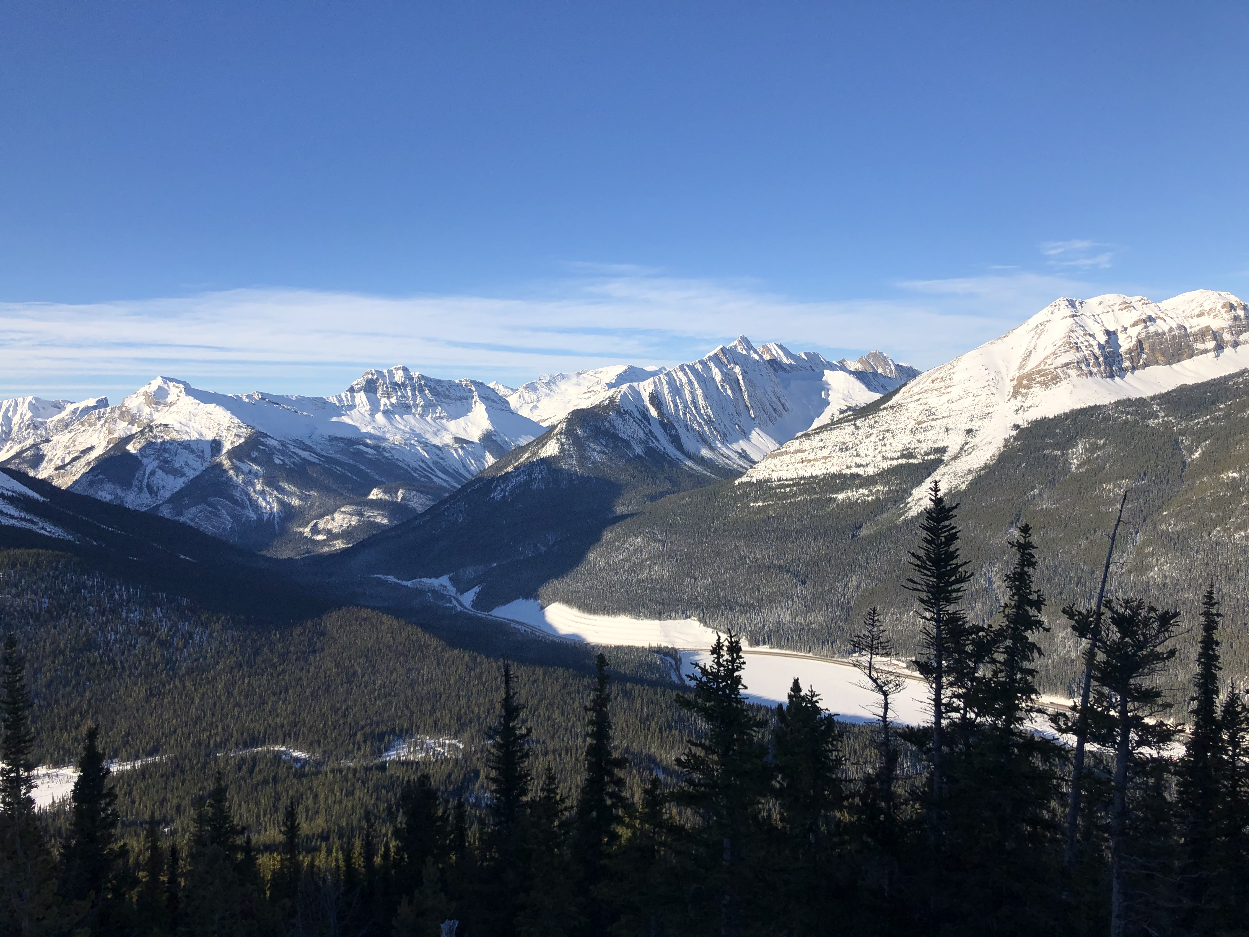 A splitboarder hiking up a snowy slope in the backcountry.