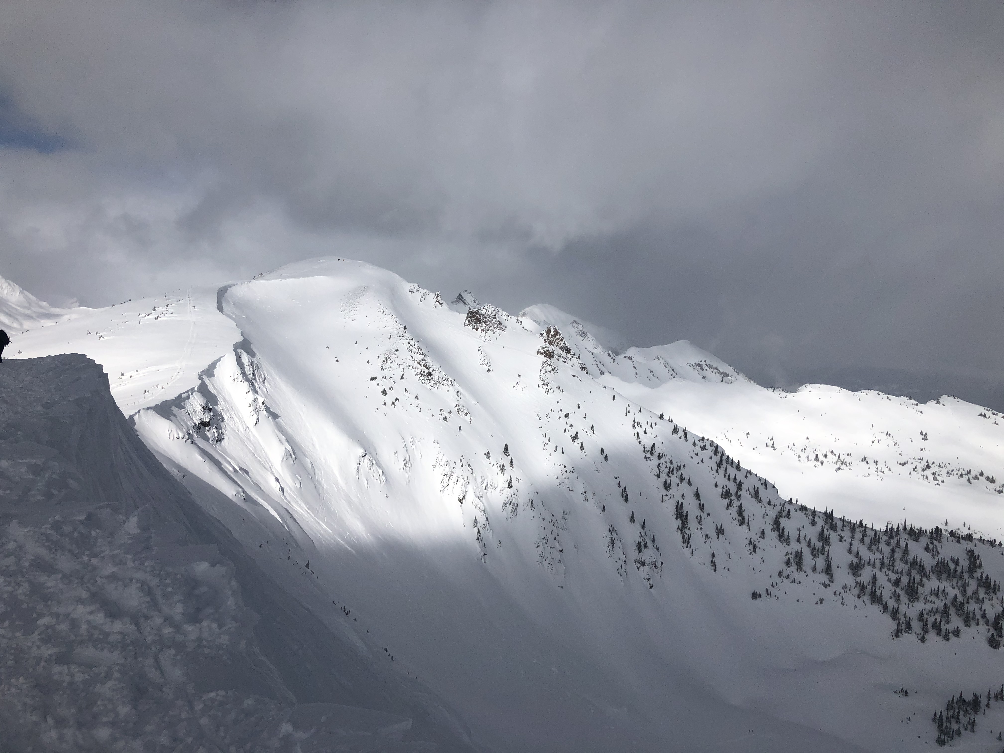 A person hiking on a snowy trail with microspikes.