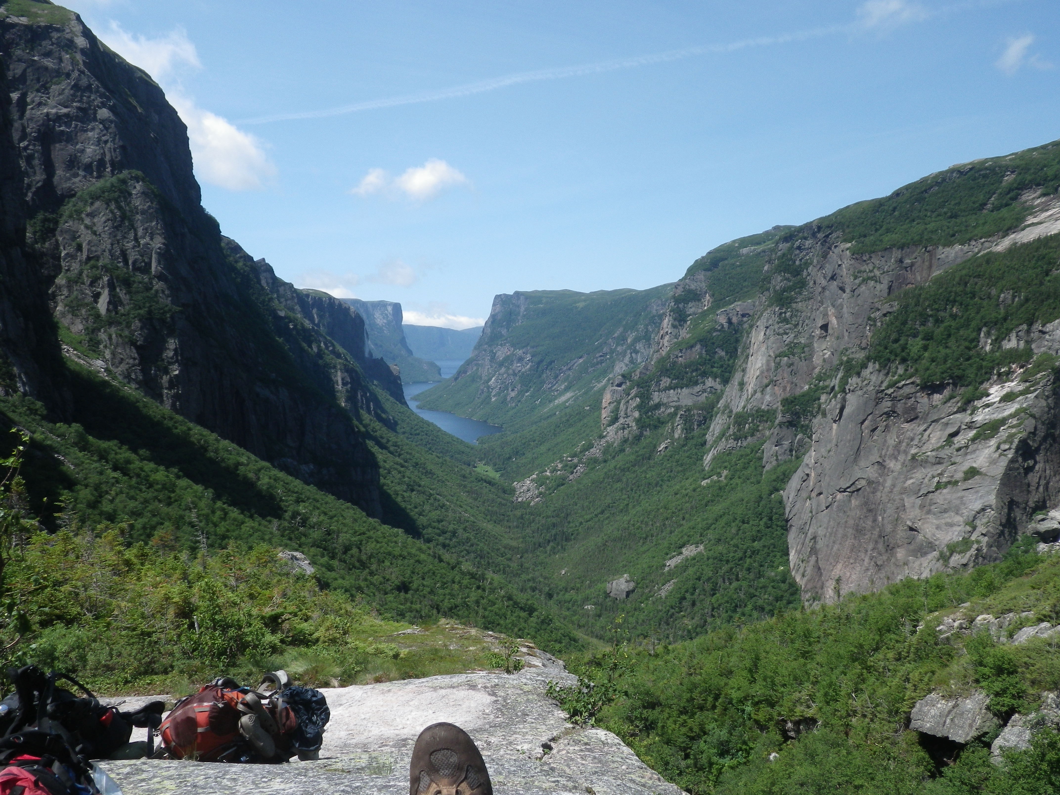 A hiker looking out over a vast, fjord-like landscape on the Long Range Traverse.