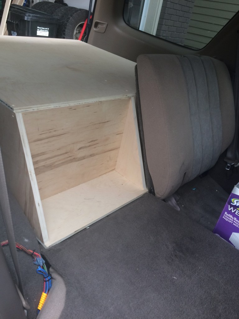 The wooden storage unit aligning with the folded-down rear seats.