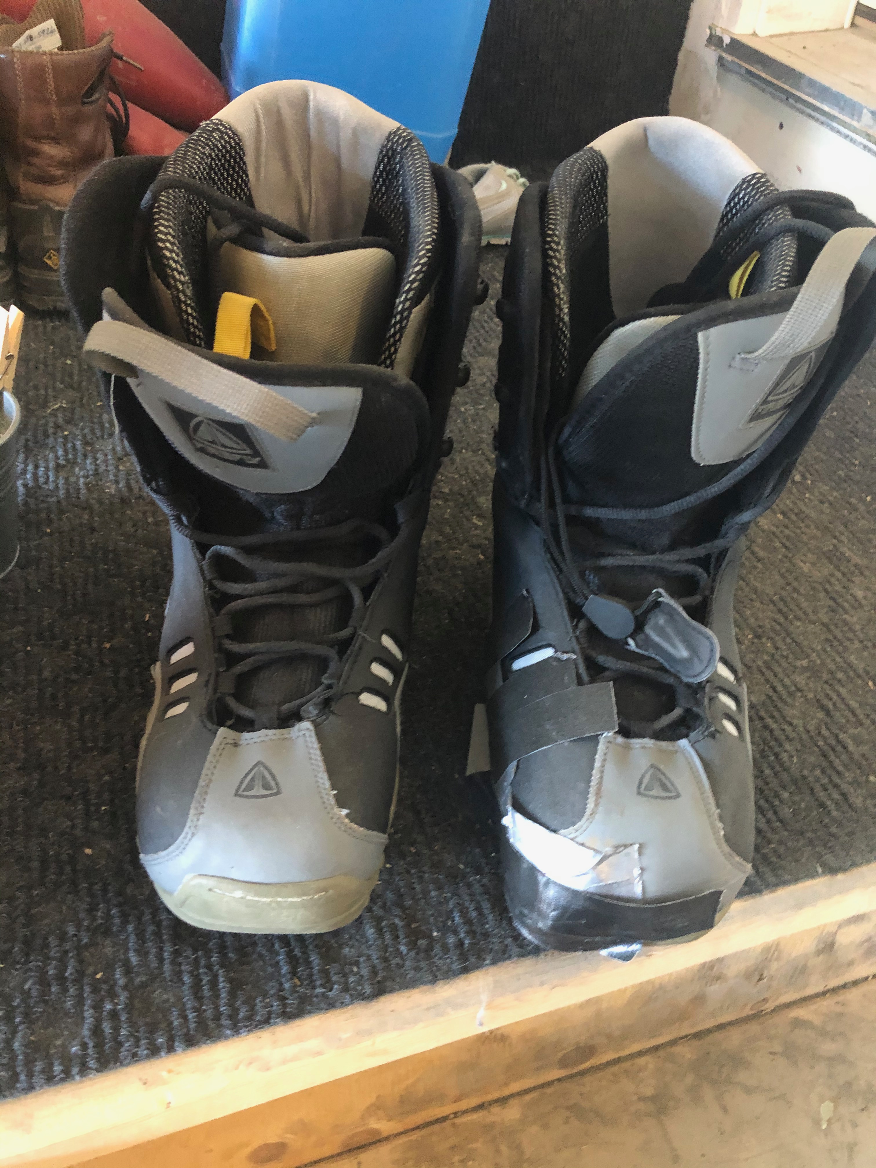 An old pair of snowboard boots with visible wear and tear.